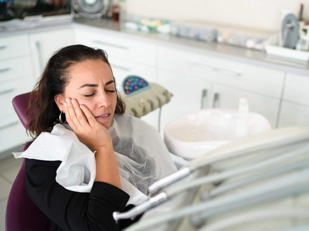 a woman in a dental checkup chair in need of an emergency dentist appointment due to jaw pain