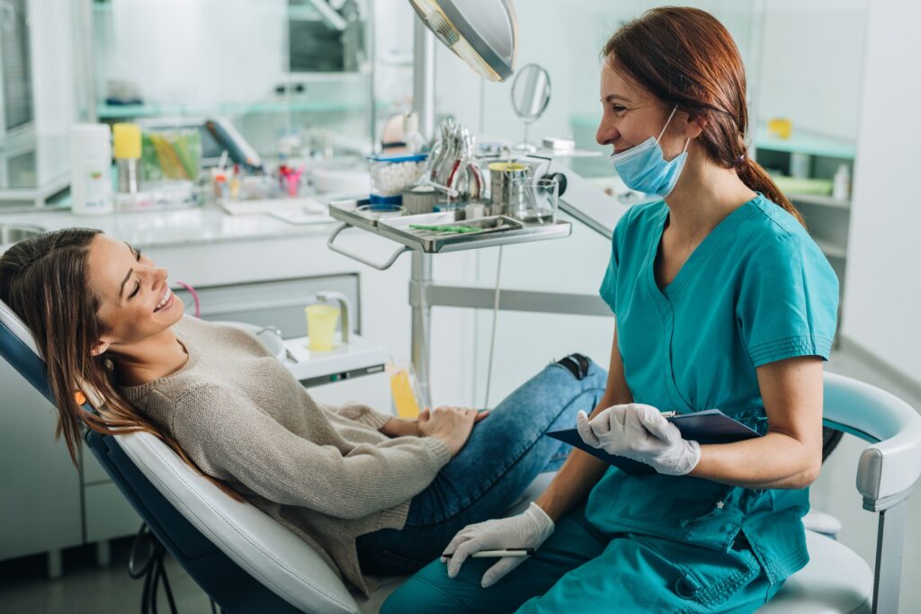 a woman in a dental chair consulting with her dental hygienist