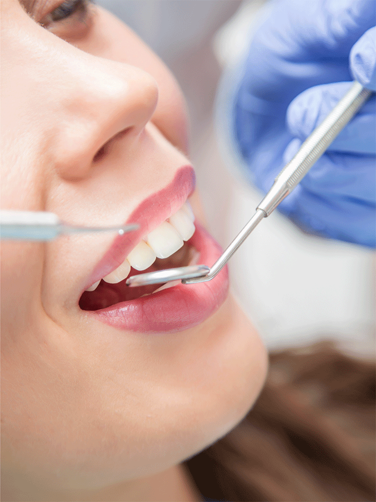 a dentist using dental tools on a young woman's mouth for a dental checkup